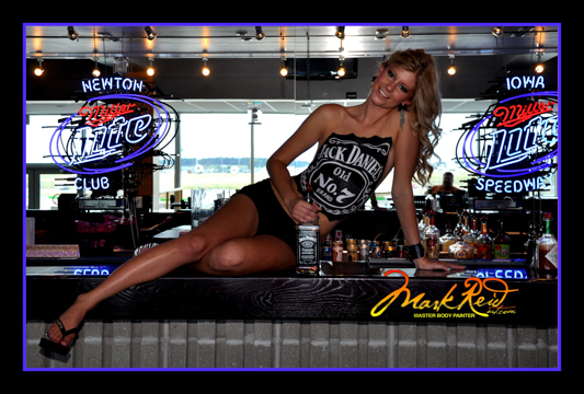 blonde woman sitting on a bar with a jack daniels logo painted on her chest